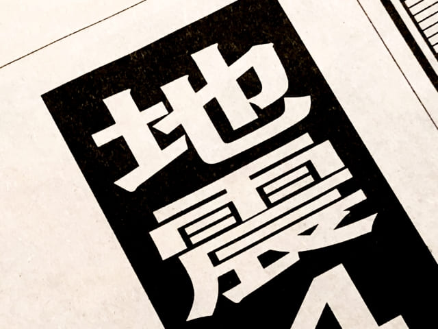 「地震」と書かれた新聞