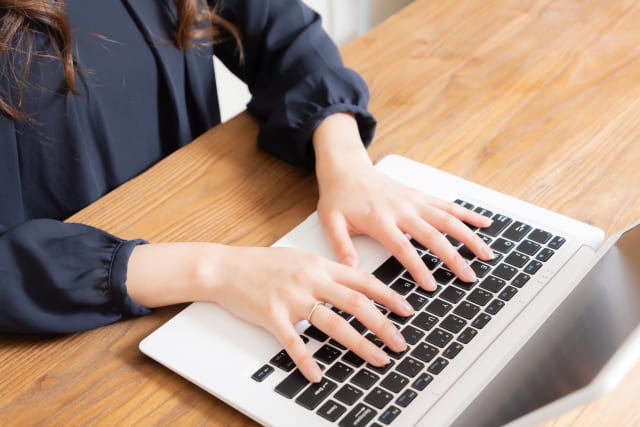 両手でキーボードを叩く女性