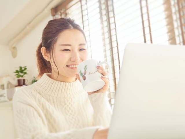パソコンを使用する笑顔の女性