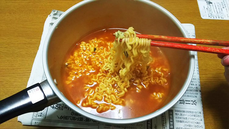 インスタントラーメンを箸で持つ