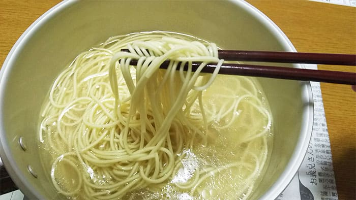 ラーメンを箸でつまむ