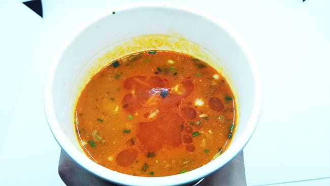 赤い色をしたラーメンのスープ